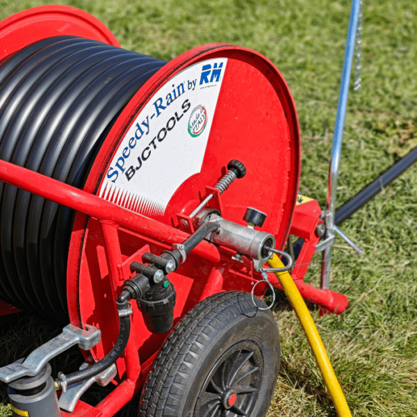 Nahaufnahme des Speedy-Rain 300 Bewässerungswagens mit stabilem Schlauch, Druckregler und Metallrahmen